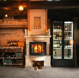 a bar with a fireplace and a shelf of alcohol at Grå Gåsen in Burgsvik