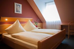1 dormitorio con 2 camas y ventana en Landgasthof Linden, en Linden