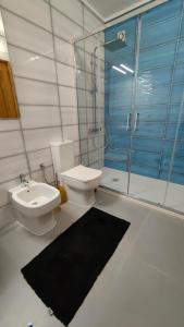La salle de bains est pourvue de toilettes, d'un lavabo et d'une douche. dans l'établissement WHAT apartment, à Gafanha da Vagueira