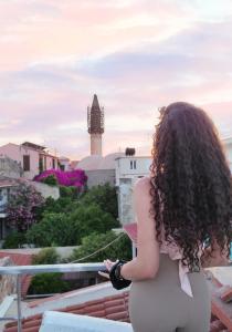 Una mujer parada en un balcón con vistas a la ciudad en Casa Di Sofia en Rethymno Town