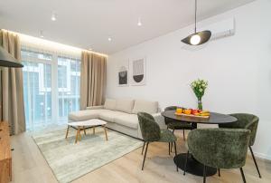 a living room with a couch and a table and chairs at #stayhere - New & Stylish Minimalistic 1BDR Vilnius City Center in Vilnius