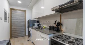 a kitchen with a stove and a stove top oven at JRR Stays - JVC Bloom Tower B 605 Amazing Studio Sleeps 2 in Dubai
