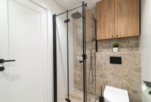 a bathroom with a shower with a glass door at #stayhere - New & Stylish Minimalistic 1BDR Vilnius City Center in Vilnius +19 photos