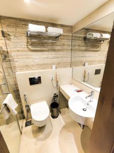 a bathroom with a toilet and a sink at Ramee Guestline Hotel Khar in Mumbai