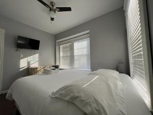 een slaapkamer met een wit bed en een plafondventilator bij Stay with Jay in Cleveland 3 in Cleveland