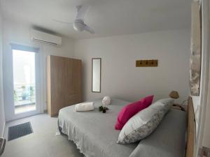 a bedroom with a bed with pink and white pillows at Apartamento en Na Macaret B in Na Macaret