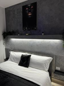 una camera con un grande letto con testiera nera di Il cortiletto28 Rooms & House a Siracusa