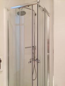 um chuveiro com uma porta de vidro na casa de banho em Casinha da Estrela em Lisboa