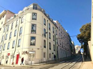 un grand bâtiment blanc au coin d'une rue dans l'établissement Casinha da Estrela, à Lisbonne