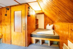 ロキトニツェ・ナト・イゼロウにあるRoubenka Muštelkaの木造キャビン内のベッド1台が備わる小さな客室です。