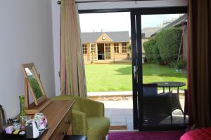uma sala de estar com uma porta aberta para um quintal em Brackness House Luxury B&B em Anstruther