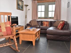 a living room with a leather couch and a table at 2 bed in Conwy Valley SKN09 in Llanrwst