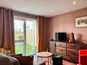 - un salon avec une télévision sur une commode et une fenêtre dans l'établissement Rêve Perdu / studio PJ, à Bruges