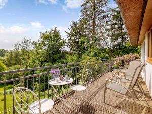 a balcony with chairs and a table with a view at 3 bed property in Godshill New Forest 56431 in Godshill