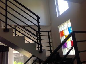 eine Wendeltreppe mit Buntglasfenster in der Unterkunft Elegance Villa in Boralesgamuwa