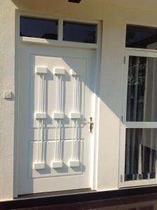 a white door with a railing on it at Elegance Villa in Boralesgamuwa +4 photos