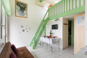a living room with a table and a green stairway at Bidart - balcon - Proche plage in Bidart