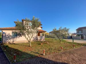 een huis met een tuin met bomen en een stenen weg bij David One in Novigrad Istria