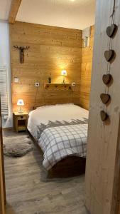 1 dormitorio con 1 cama en una habitación con paredes de madera en Appartement coeur de station Valfrejus 6 pers, en Modane