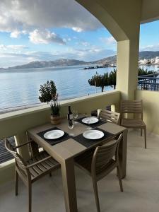 a table and chairs on a balcony with a view of the water at Samanthas LUXURY APARTMENT in Haraki