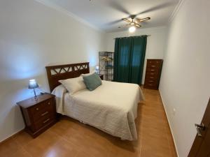 1 dormitorio con 1 cama y ventilador de techo en Casa Kanete, en Cala