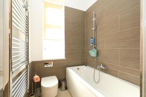 La salle de bains est pourvue d'une baignoire, de toilettes et d'un lavabo. dans l'établissement Alan's Downtown Apartment, à Zagreb