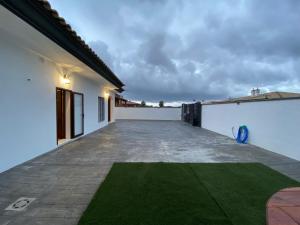 a patio of a house with a green lawn at Casa Kanete in Cala