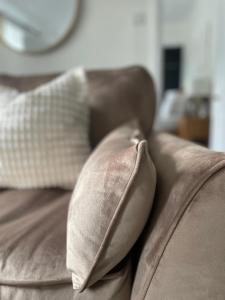 a brown couch with two pillows on it at Old Hundred View in Tormarton