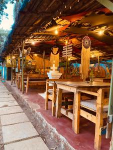 an outdoor restaurant with wooden tables and benches at Gaia Hostels in Anjuna