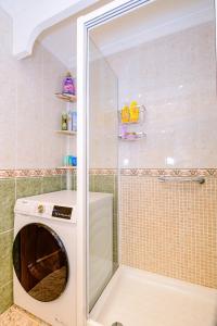 una lavatrice in un bagno accanto alla doccia di Home&Holiday Goleta with parking-option a Torrevieja