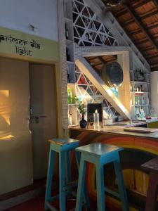 twee blauwe krukken in een bar in een restaurant bij Gaia Hostels in Anjuna