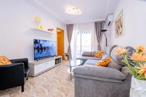 un soggiorno con un divano e una TV di Home&Holiday Goleta with parking-option a Torrevieja
