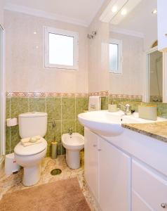 un bagno con un water, un lavandino e uno specchio di Home&Holiday Goleta with parking-option a Torrevieja Altre 15 foto