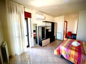 um quarto com uma cama e uma televisão em Le Ceramiche - Hotel Residence ed Eventi em Montalto Uffugo
