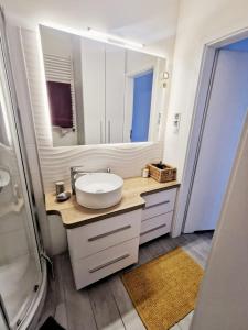 uma casa de banho com um lavatório e um espelho em Mandala Art Apartment PL LT EN em Suwałki