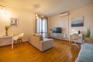 uma sala de estar com um sofá, uma mesa e uma televisão em ComfortHouse in Ravenna em Ravenna