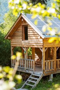 eine Holzhütte mit einem Sonnendach und einer Veranda in der Unterkunft Mestia Eco Huts 2 in Mestia