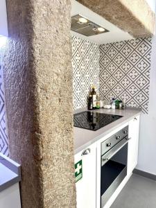 uma cozinha com um balcão branco e uma parede em Casa da Prata em Lisboa