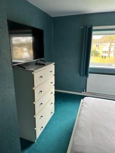 a bedroom with a bed and a dresser with a television at Double room to rent 2 in Birmingham