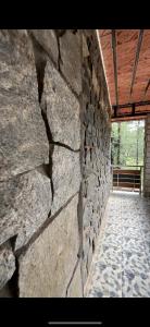 - un bâtiment en pierre avec un mur en pierre et une fenêtre dans l'établissement Sai, à Ambātturai