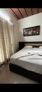 - une chambre avec 2 lits et un rideau dans l'établissement Sai, à Ambātturai