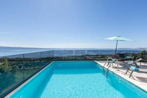 a swimming pool with a view of the ocean at Villa Perla Podstrana in Podstrana