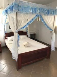a bed with a canopy in a room at Hotel le Lagon in Foulpointe