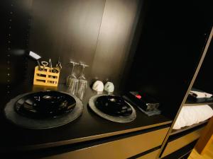 un mostrador negro con dos placas y un espejo en La chambre Cour'toise, en Stoumont