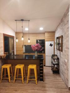 uma cozinha com um balcão com bancos amarelos em Casa rústica O NOSO VAL em Mondariz