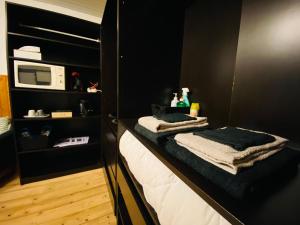sypialnia z czarnymi ścianami, kuchenką mikrofalową i ręcznikami w obiekcie La chambre Cour'toise w mieście Stoumont