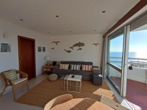 a living room with a couch with bats on the wall at 3 Castelos Sunset - Praia da Rocha in Portimão