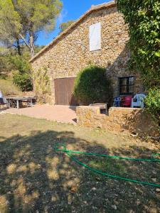 ein Haus mit einem grünen Schlauch im Hof in der Unterkunft Masia Rustica Costa Brava in Calonge