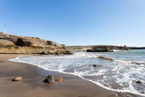 a beach with some rocks in the water at EK Abades El Caleton in Abades