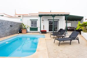 una casa y un patio con piscina y sillas en EK Abades El Caleton, en Abades